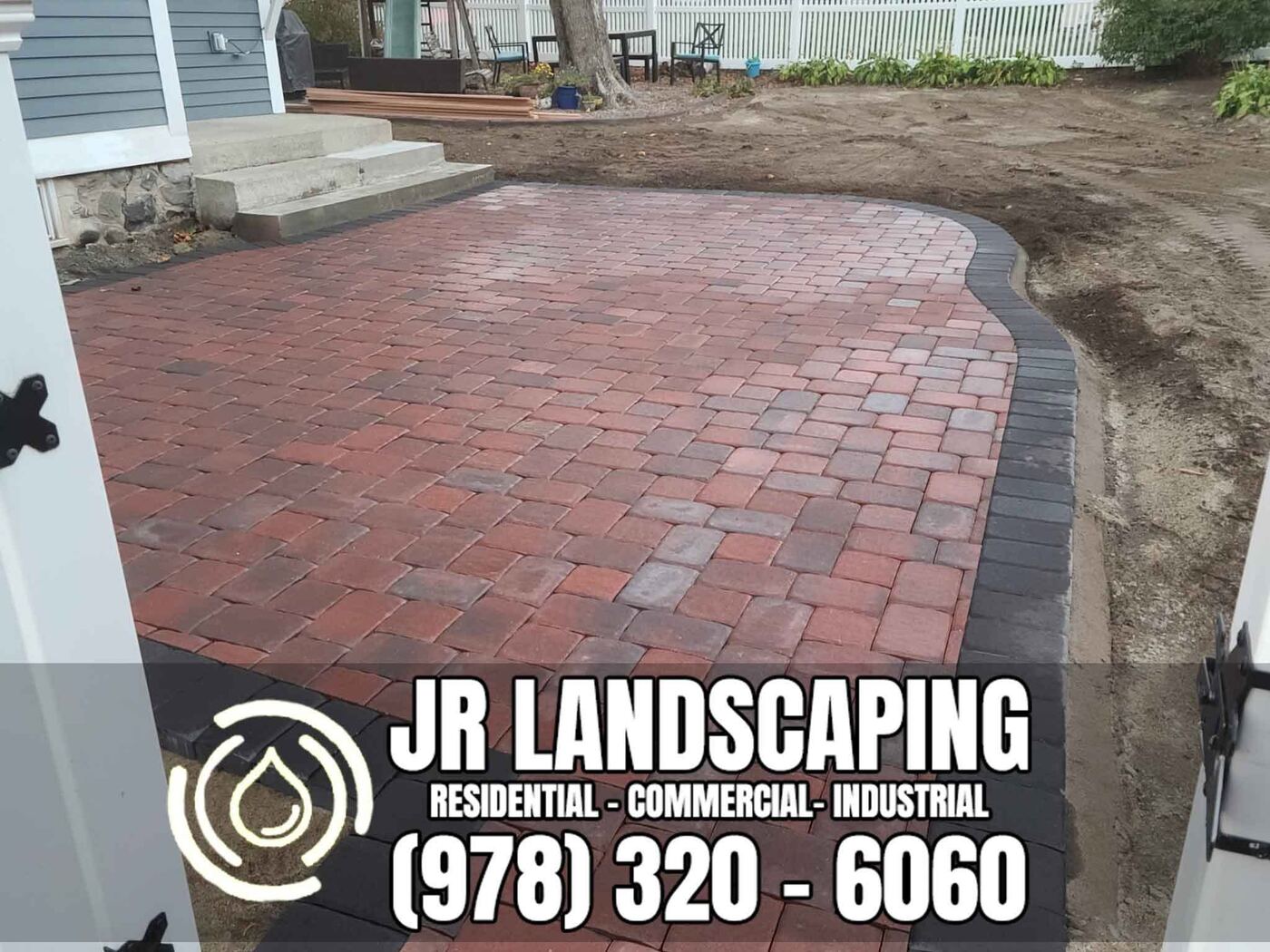 Paver patio wrapping around a concrete entry stairway